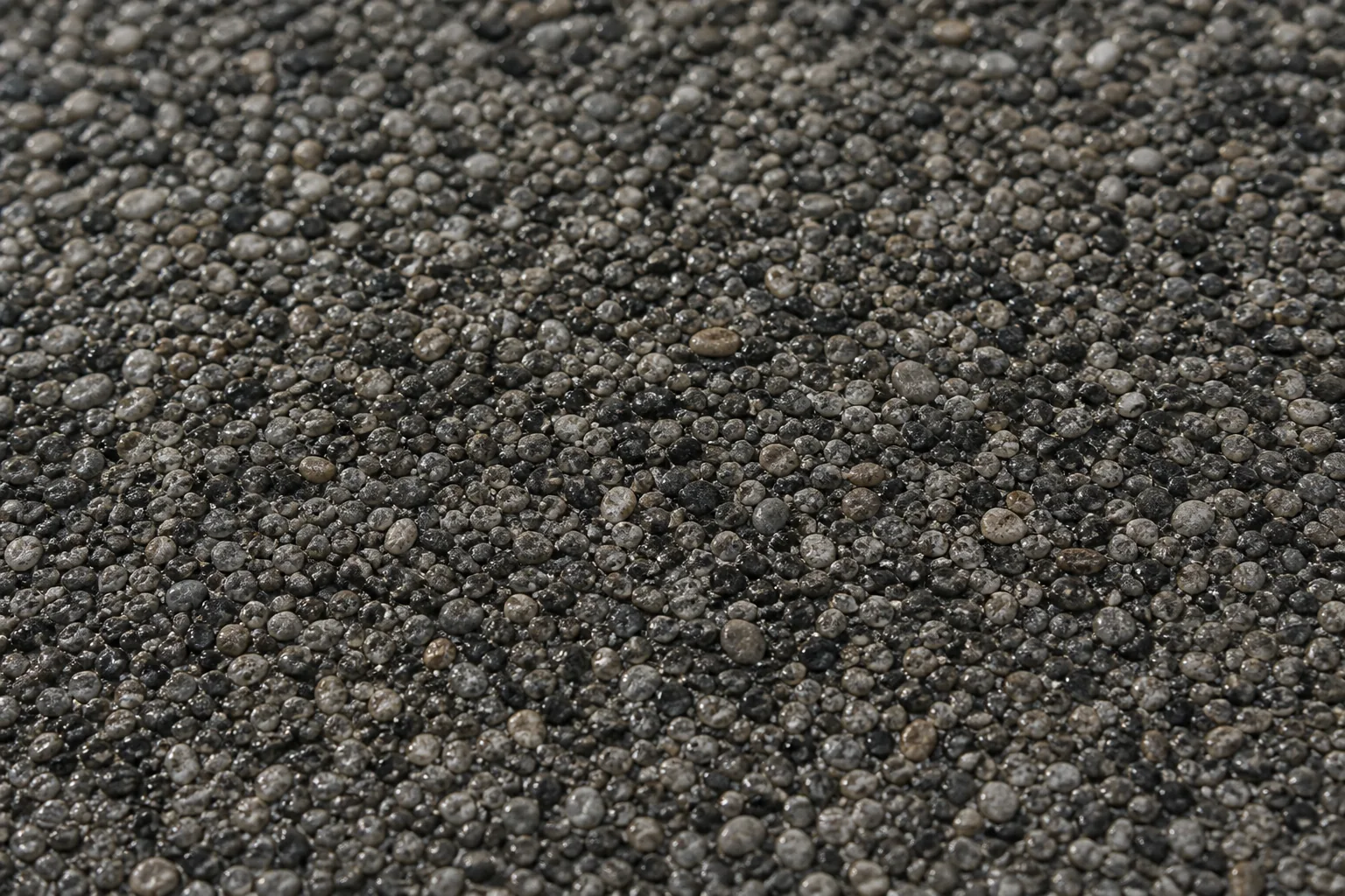 Detail eines Steinteppichs mit dunkler Körnung
